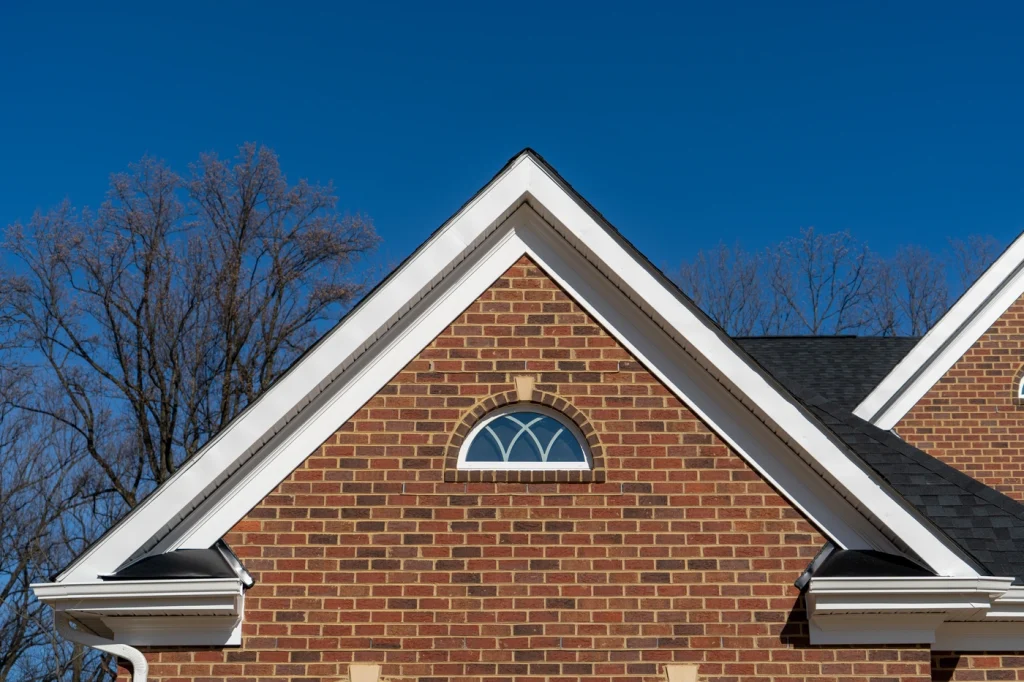 gable shingle roof with half round window installation on brick home in maryland