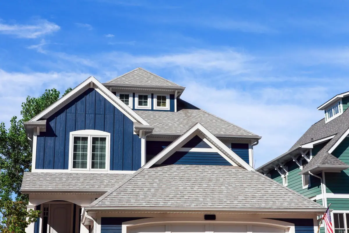 house with grey shingles roof and blue siding