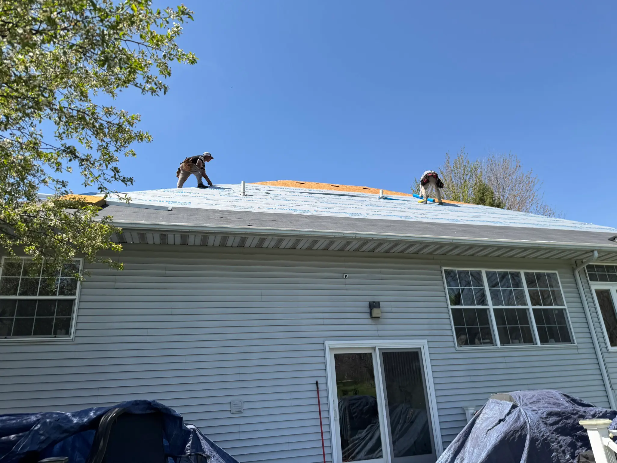 workers replacing old roof in small house