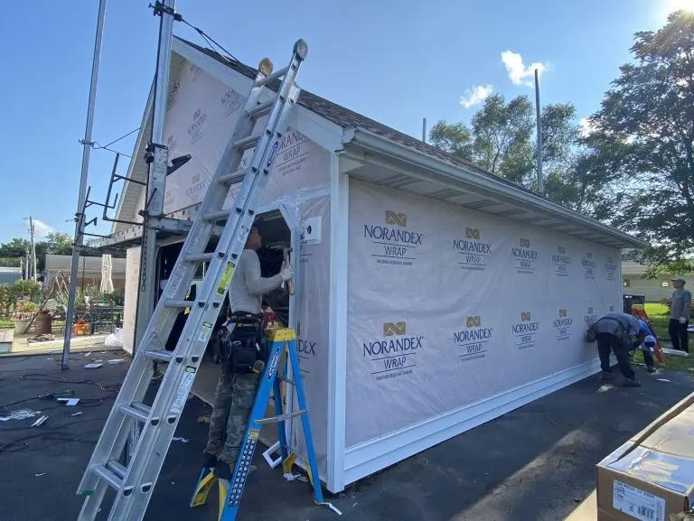 workers repairing siding small warehouse