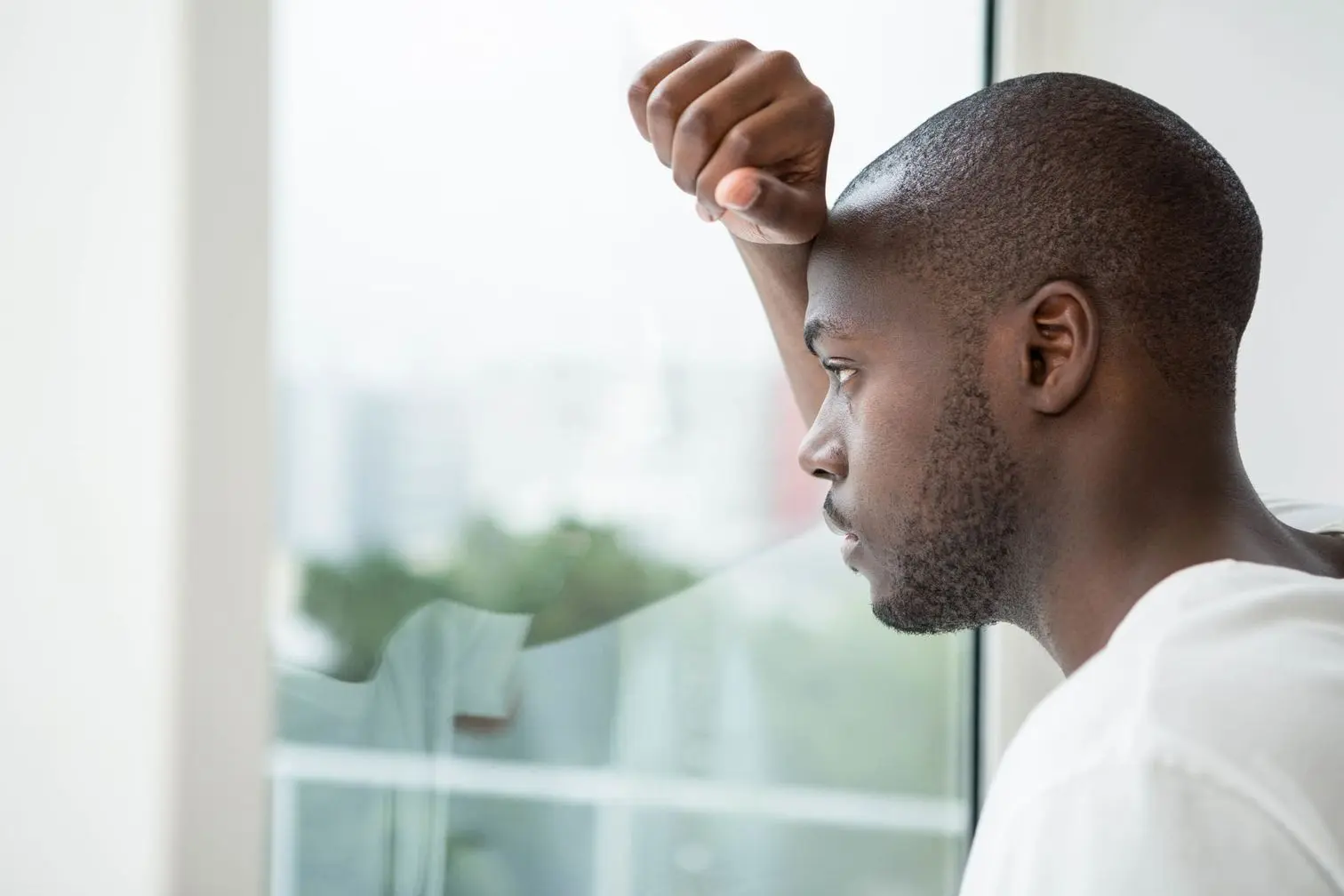 Thoughtful man looking out the window in bedroom at home Visual Journaling
