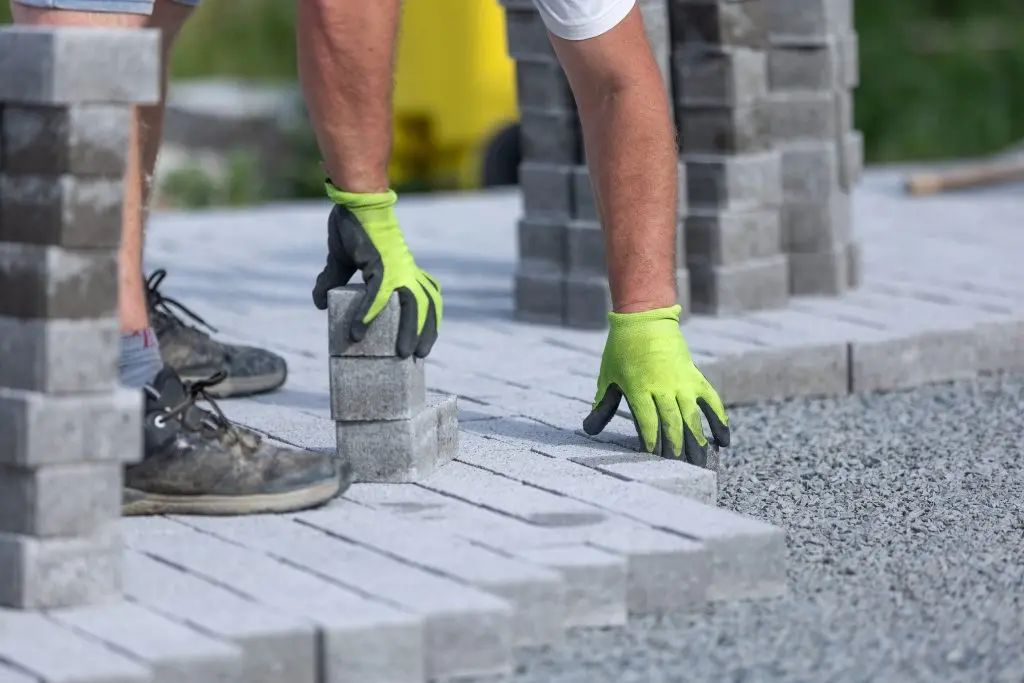 a landscaping crew doing new interlocking paving sidewalk made from concrete blocks