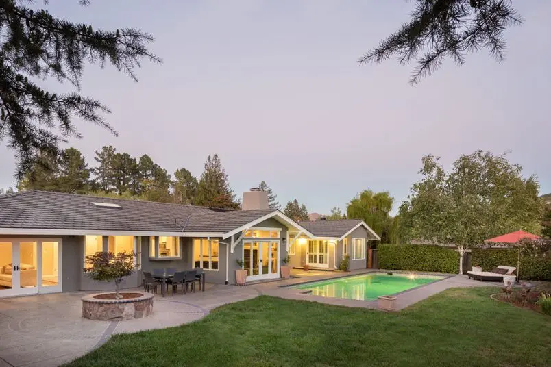 Luxury home with beautiful landscaping, including a swimming pool at sunset