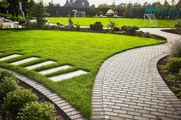 AdobeStock_314831805-scaled | Search Strategy Marketing Landscaping of the garden path curving through Lawn with green grass and walkway tiles