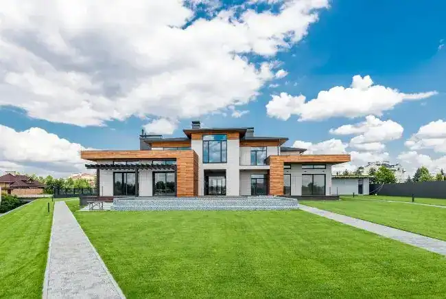 A house with an eco-friendly roofing and a spacious lawn.