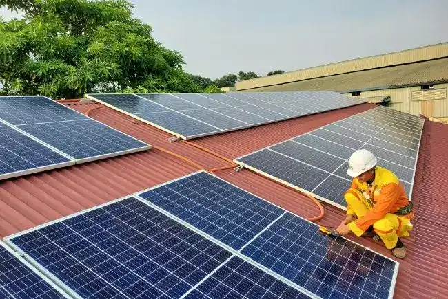 A professional installs solar panels on a roof.