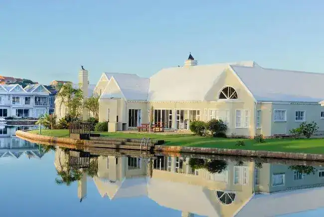 Property with white roof in front of lake.