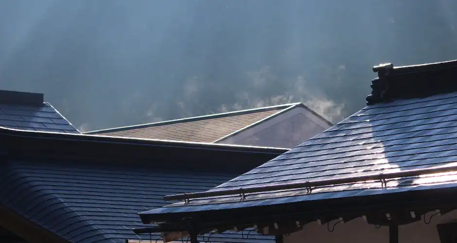the roof of a house with the sun shining through the clouds