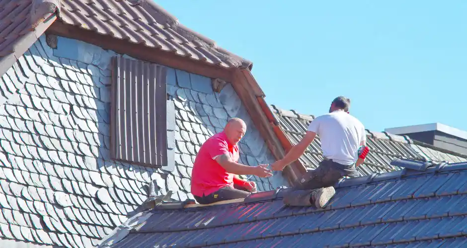 two men working on the roof of a house