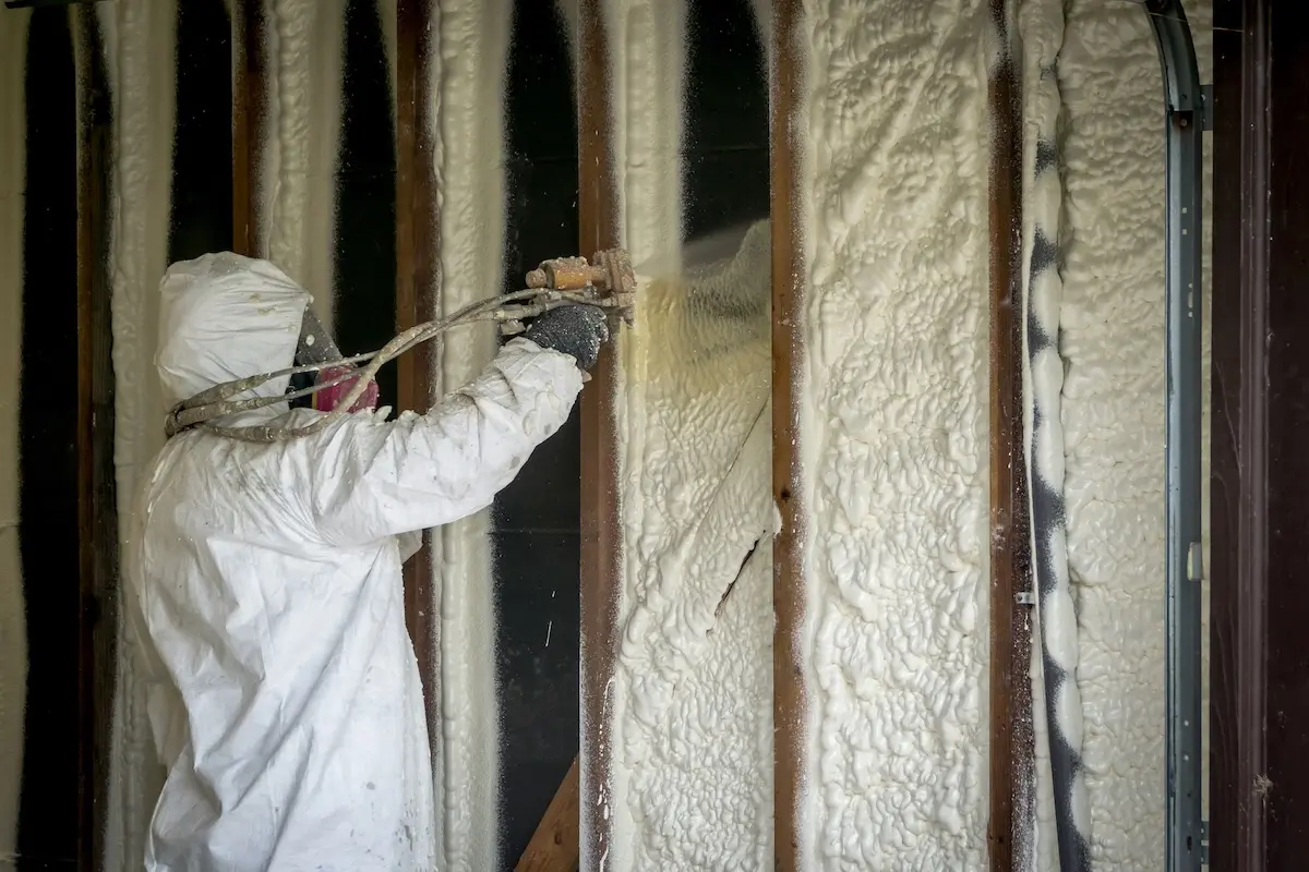 Worker spraying closed cell spray foam insulation