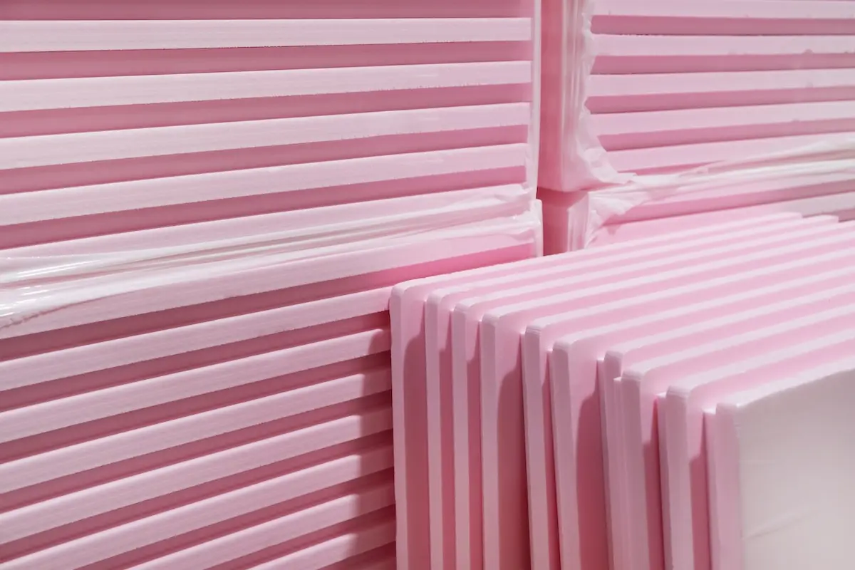 Pink Extruded Polystyrene XPS foam thermal insulation boards stacked in construction site. High Density, water absorption. Eco energy saving technology