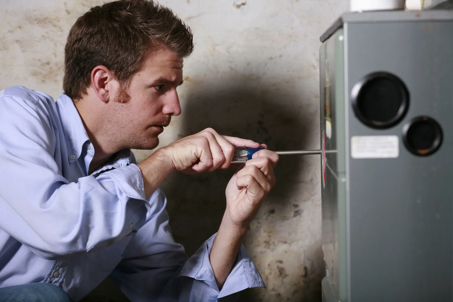 Furnace-technician-repairing-unit