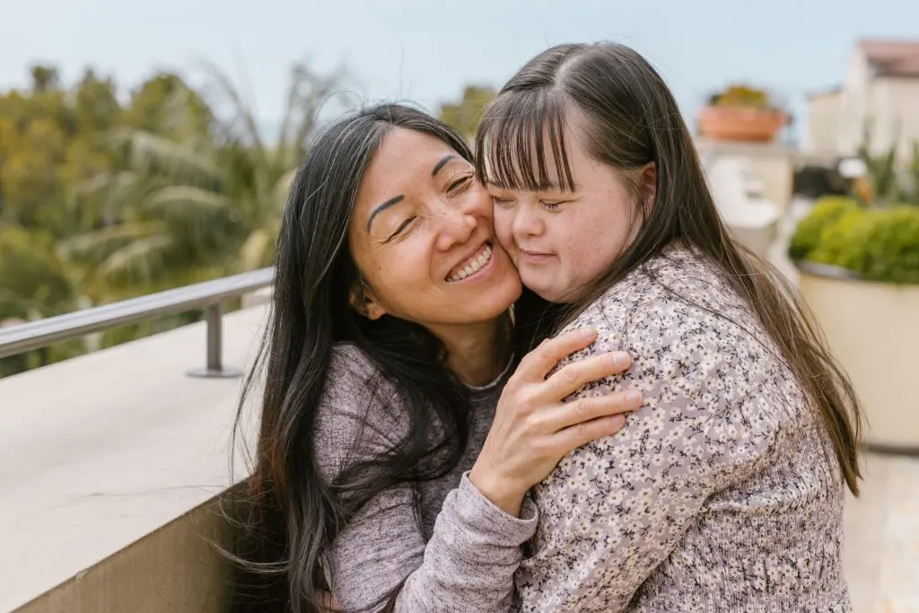 Mother embracing adult daughter with special needs, illustrating family support and special needs trust planning.