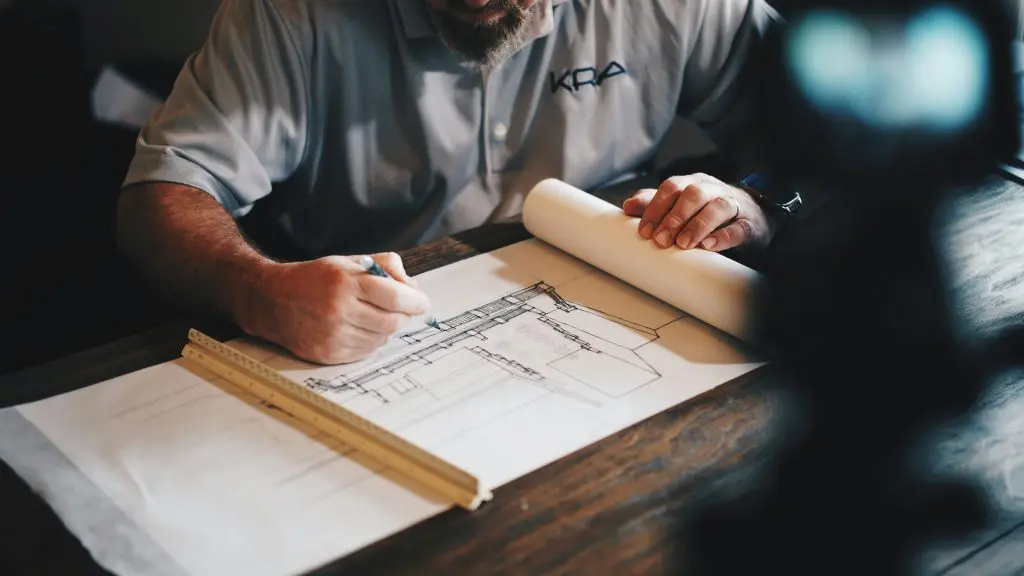 Custom home cost estimating with a contractor reviewing residential building plans and project details.