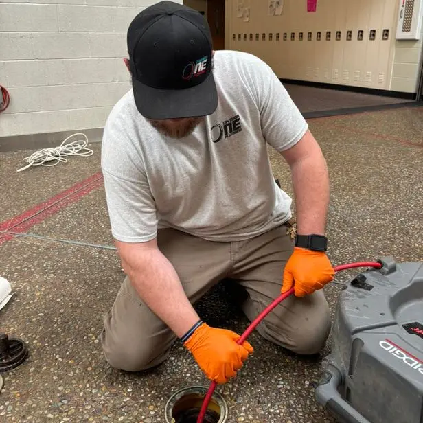 Division One Plumbing service tech cleaning drain