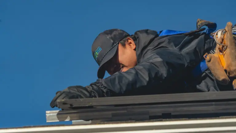 worker installing solar using both hands