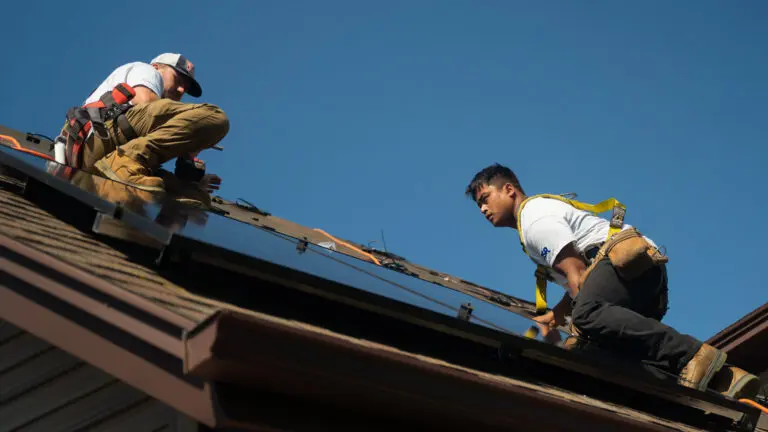 two Suncovia workers placing solar panels