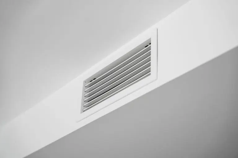White ceiling air vent grille in modern home interior, clean HVAC ventilation system