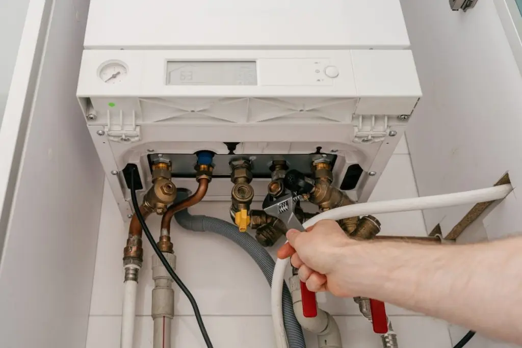 Repairman-fixing-modern-gas-boiler-in-utility-room-for-efficient-heating-