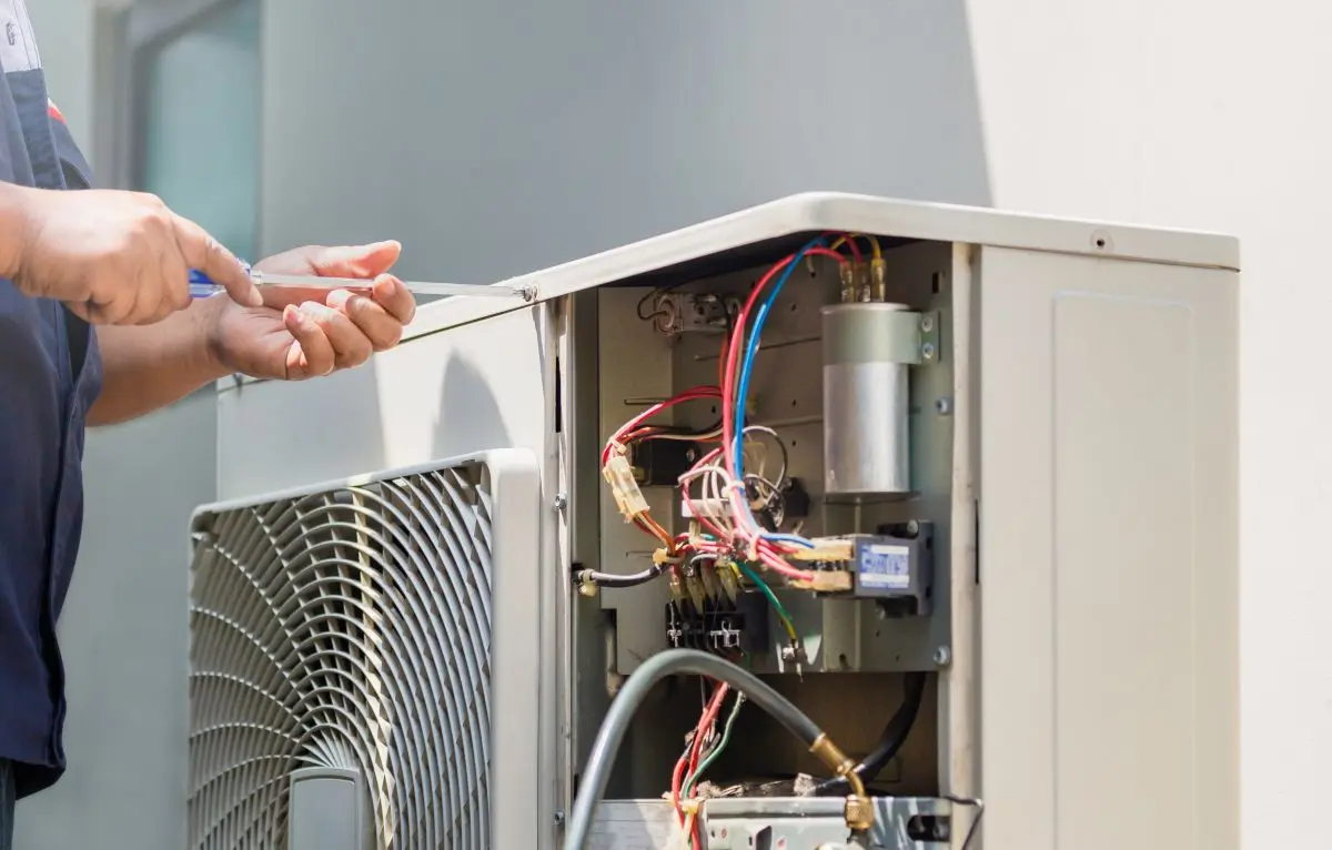 hands using a screwdriver fixing modern air conditioner, repairing and servicing