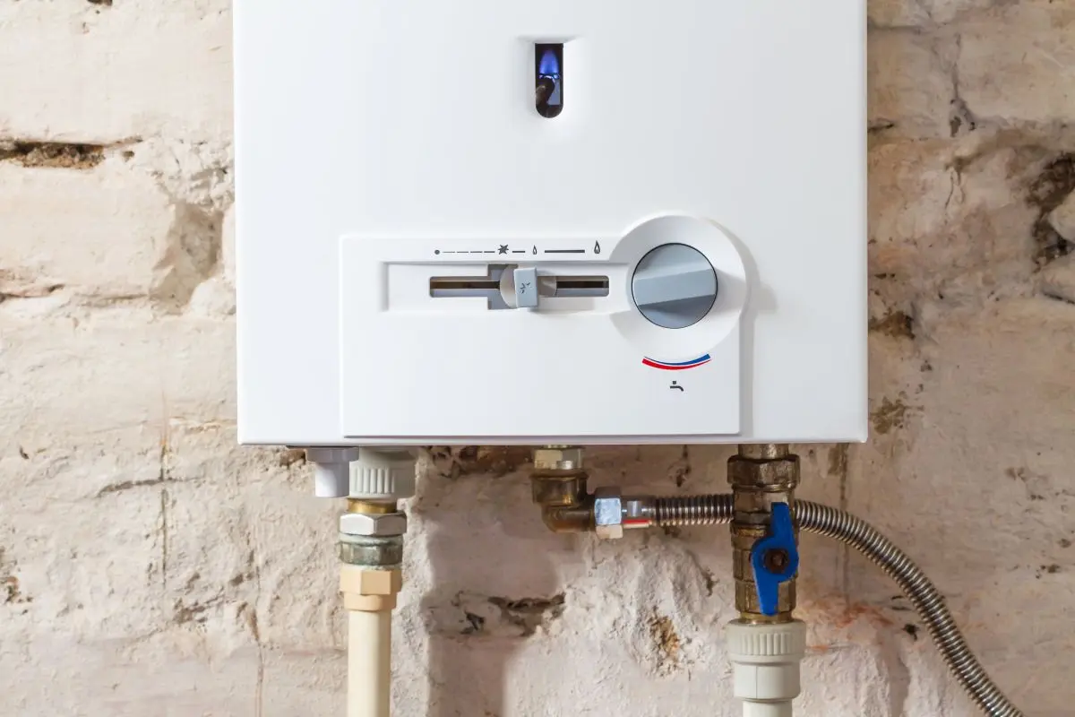 Closeup of gas water heater on a brick wall. Gas boiler in boiler room for hot water