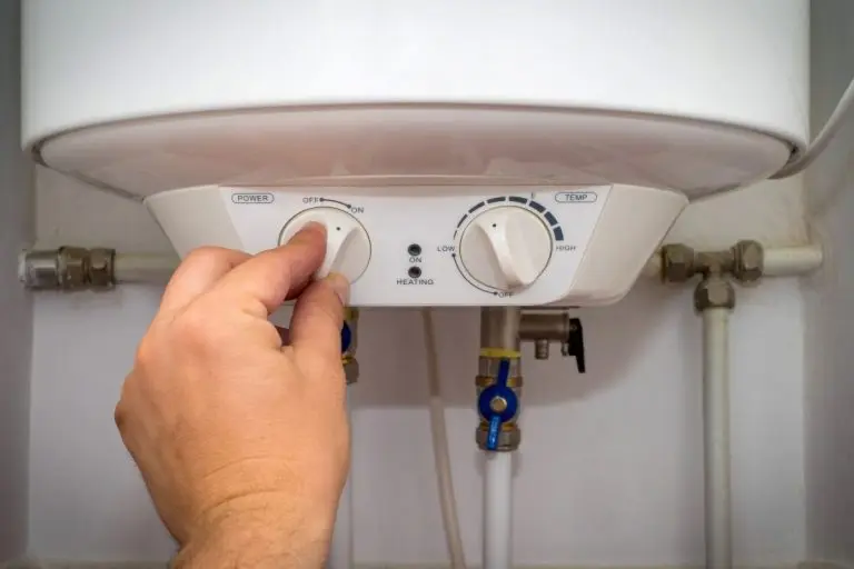 Man-turns-on-the-switch-on-control-panel-of-home-electric-water-heater-