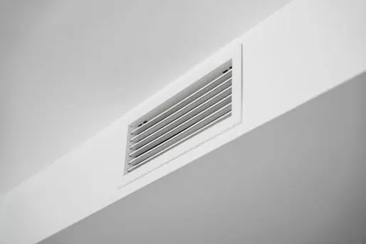 White ceiling air vent grille in modern home interior, clean HVAC ventilation system