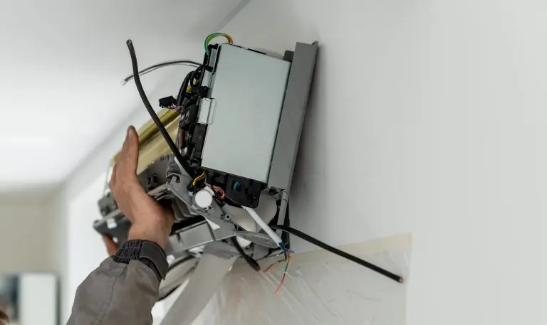 Man technician worker in uniform fixing repairing apartment air conditioner, installing wall-mounted mini split. AC unit maintenance concept