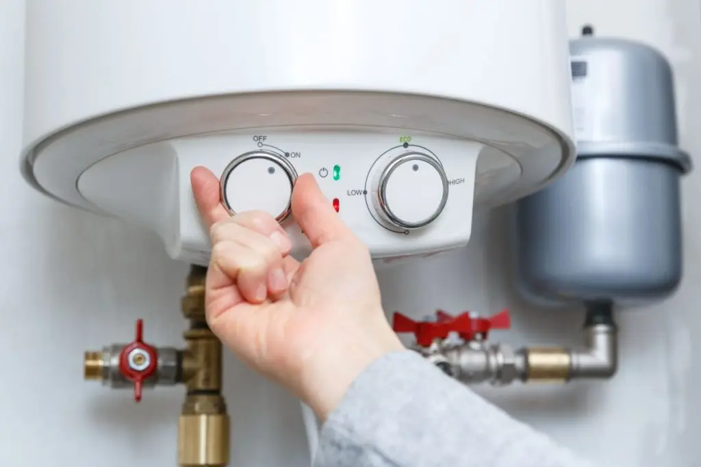 hand-turning-on-electric-water-heater-boiler (1)