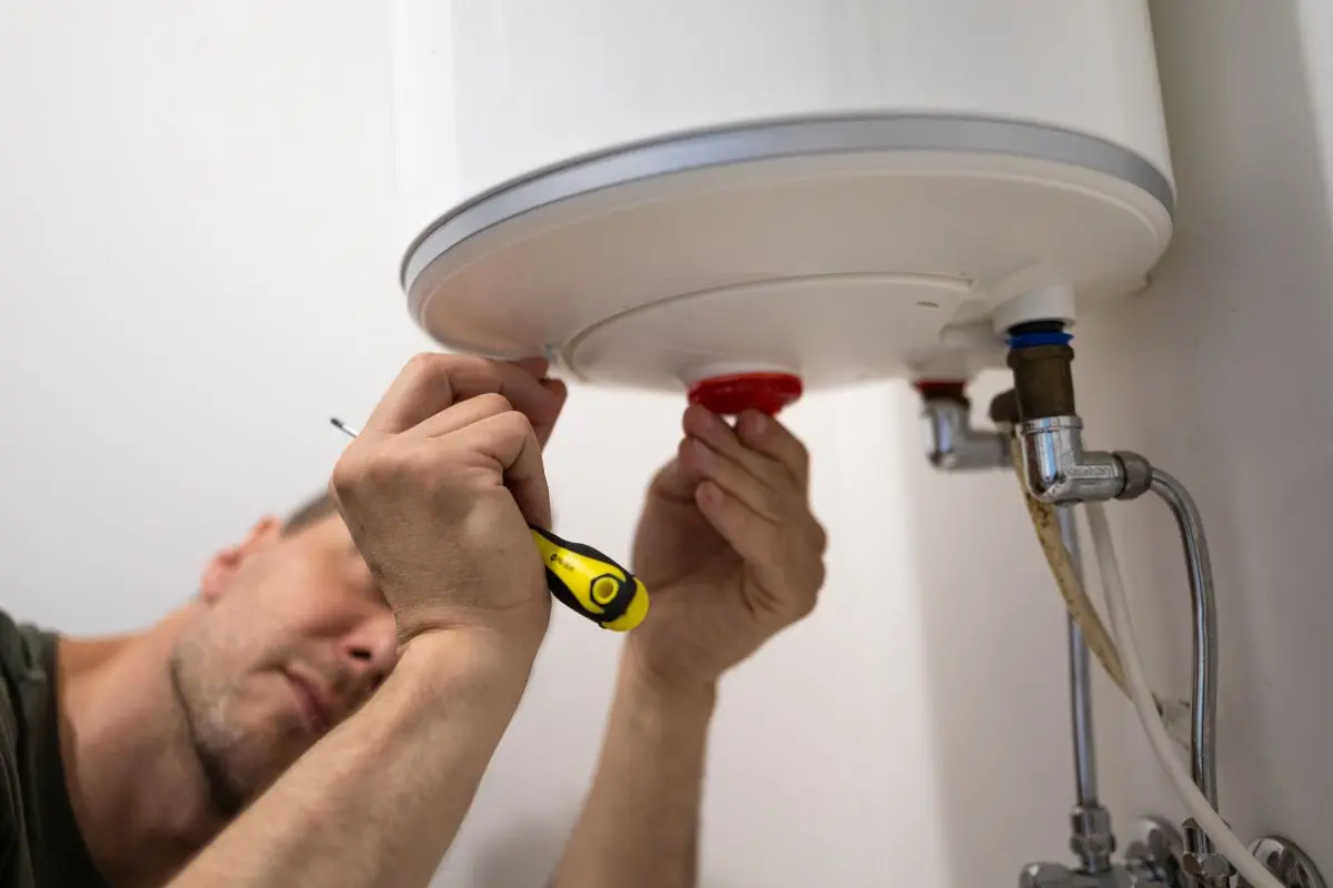 Heating repair specialist fixing apartment boiler system and checking hot water equipment during technical maintenance inside utility room