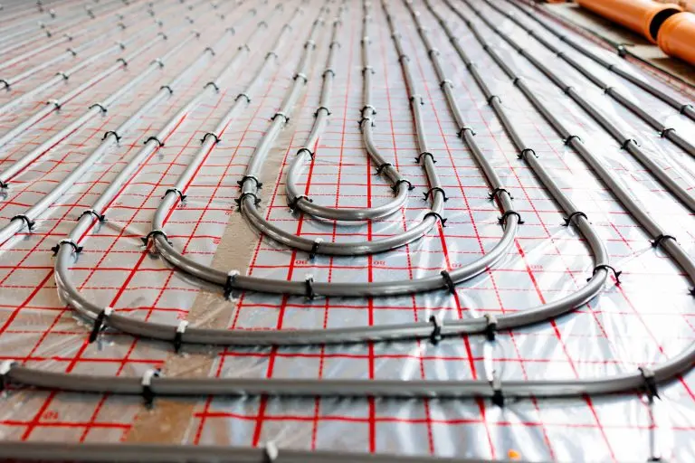 Radiant floor heating pipe installation in modern building,Close-up view of plastic pipes for radiant underfloor heating system installed on insulation layer, energy-efficient home construction.