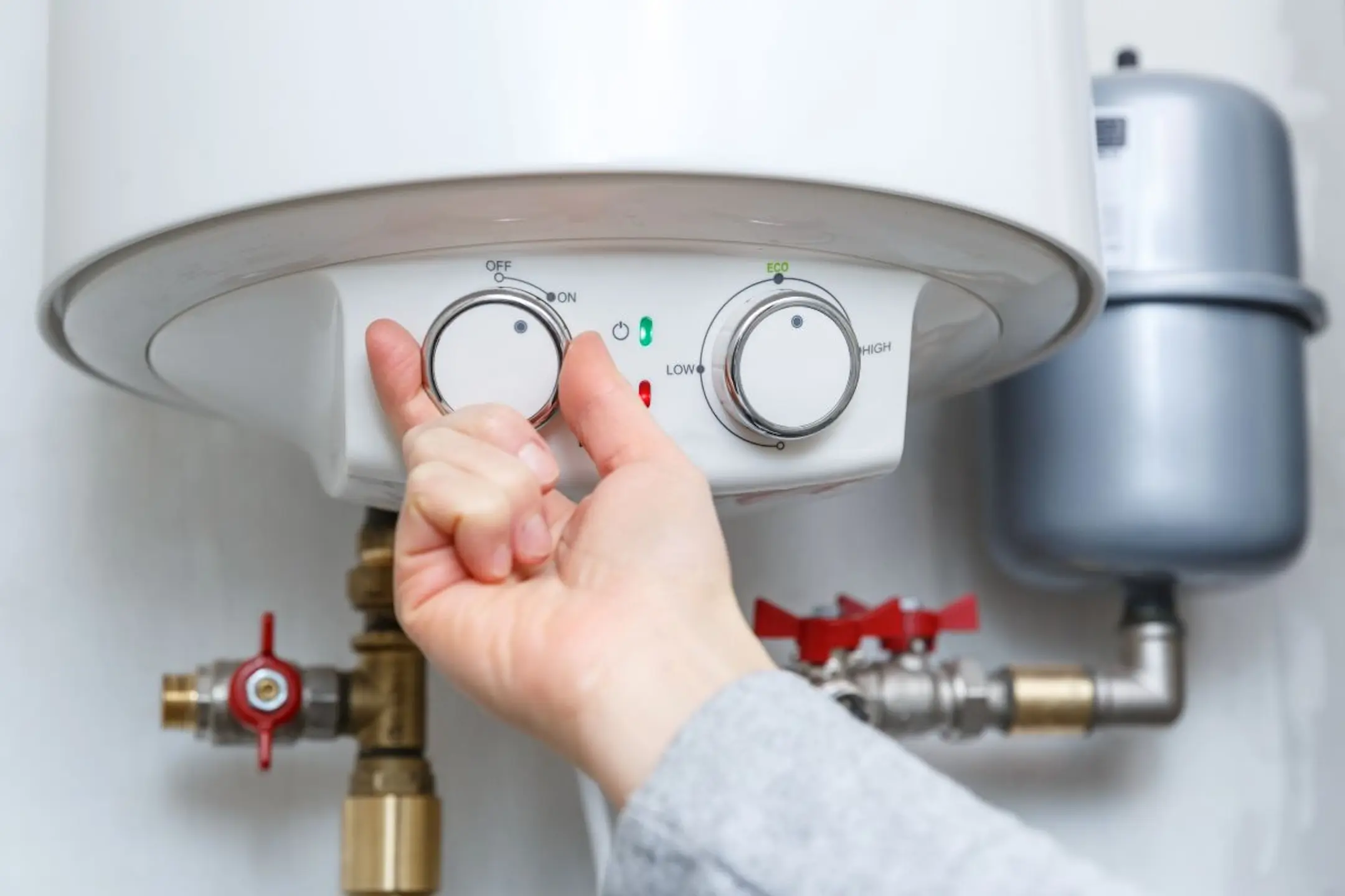 hand-turning-on-electric-water-heater-boiler