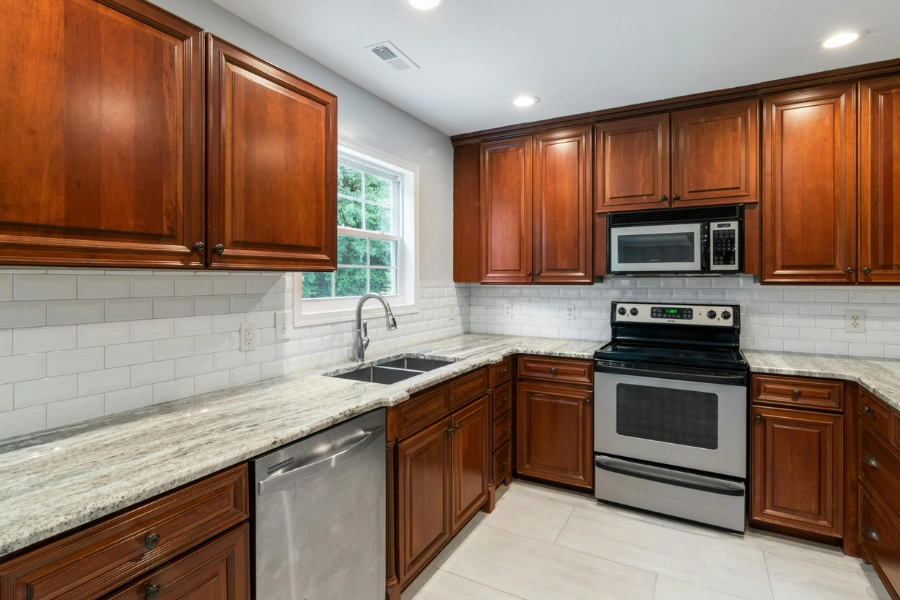Subway tile backsplash behind kitchen counters, sink, and stove.