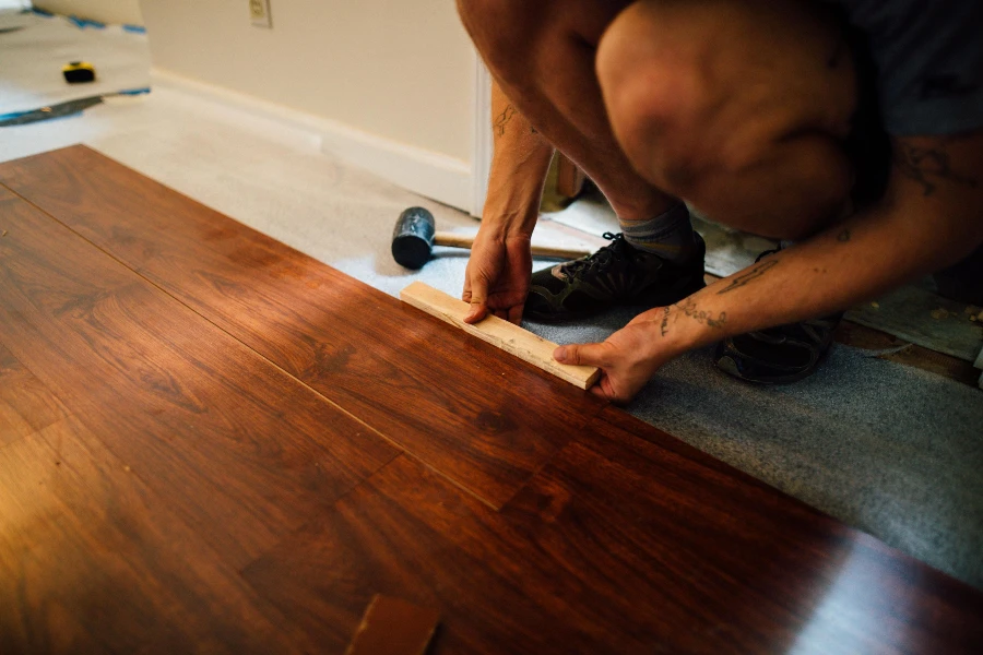 installer fitting click lock plank flooring over a prepared subfloor