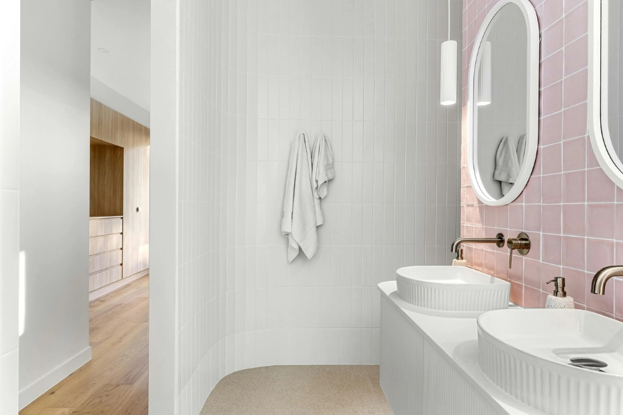 pink tiled accent wall behind sinks