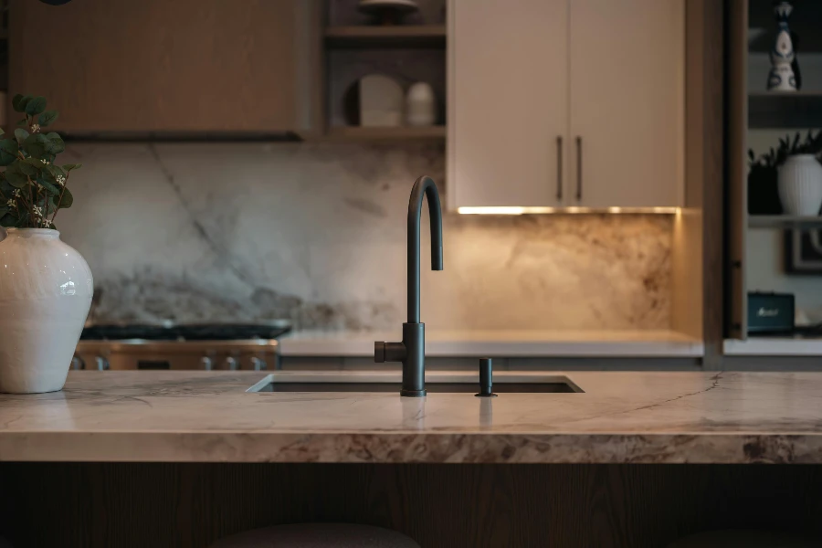 modern kitchen countertop and backsplash with cabinets and a dark faucet