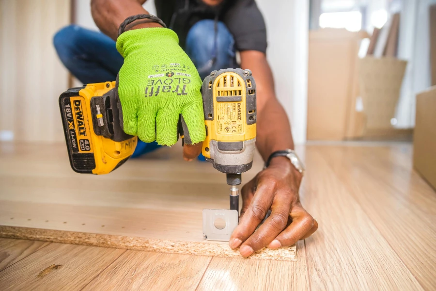 man drilling a wooden board during remodeling