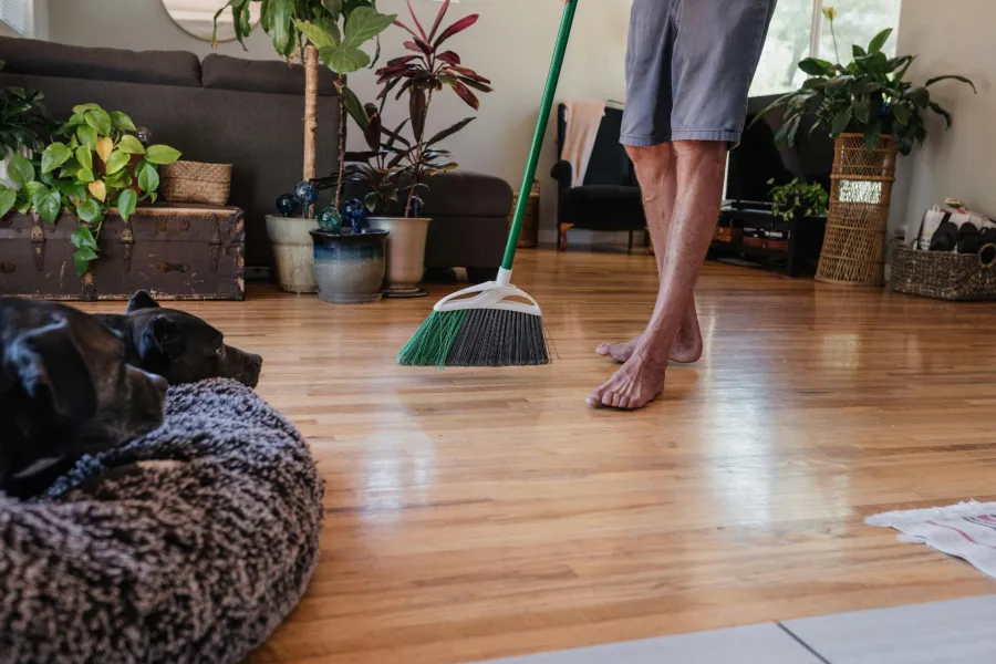 man sweeping hardwood floor