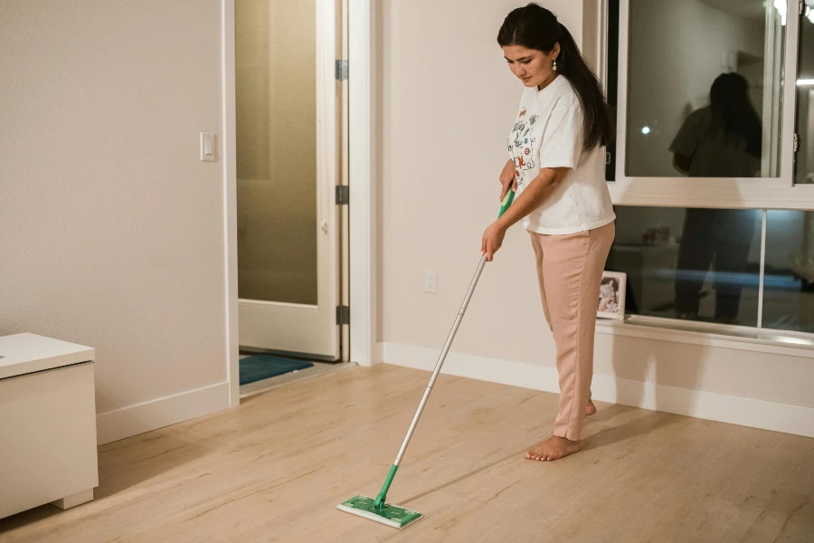 woman cleaning vinyl plank flooring with mop