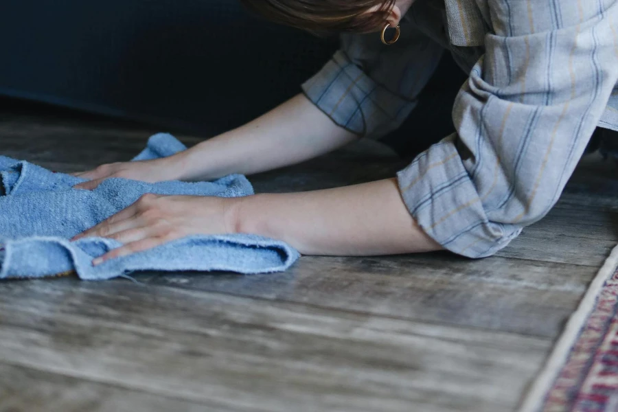woman wiping vinyl floors with soft cloth