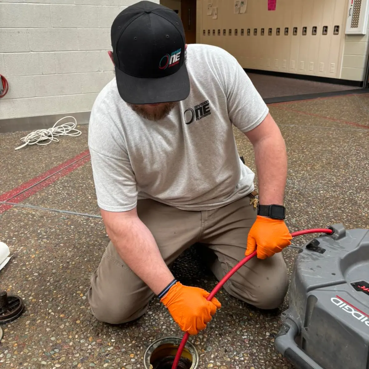 Division One Plumbing service tech cleaning drain