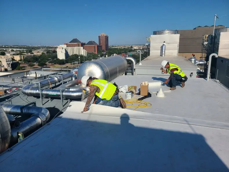 Workers installing HVAC on rooftop.