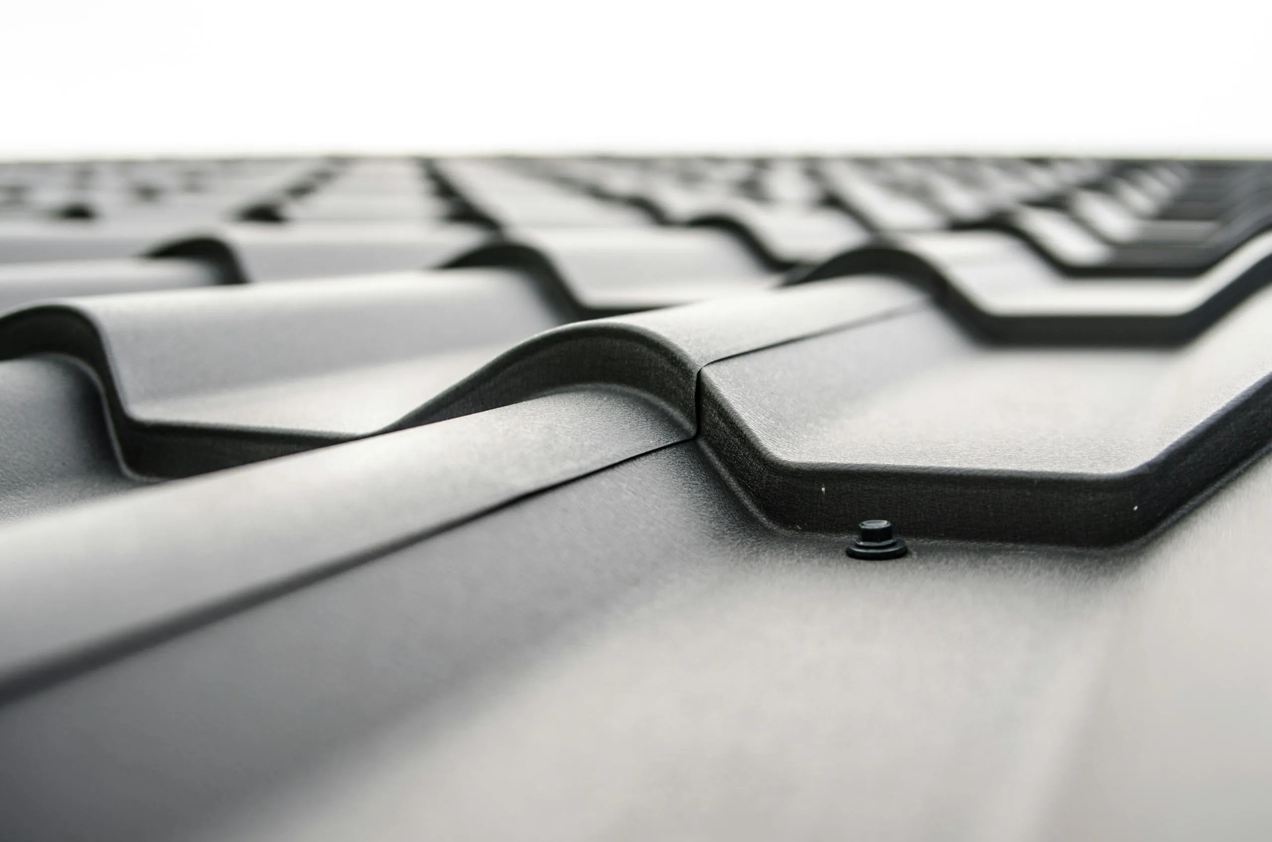 Close-up of a commercial metal roof panel profile showing rivets and structural detail