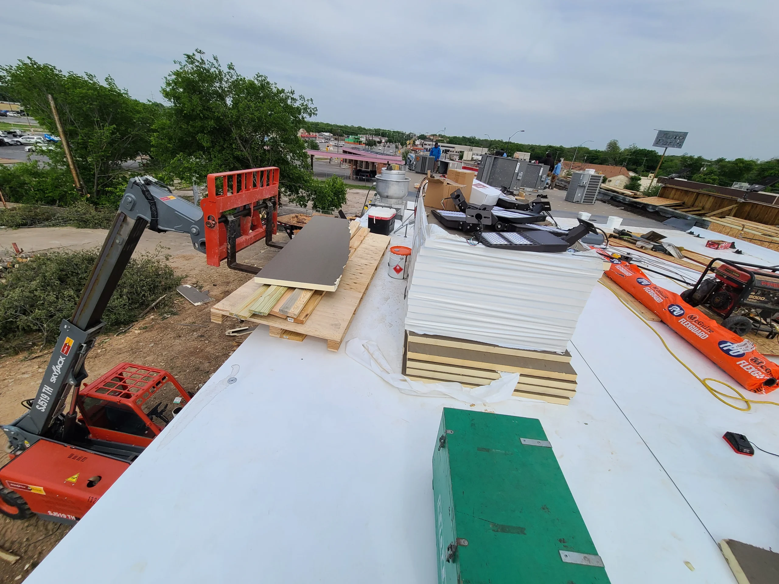 Commercial roof insulation installation using a lift