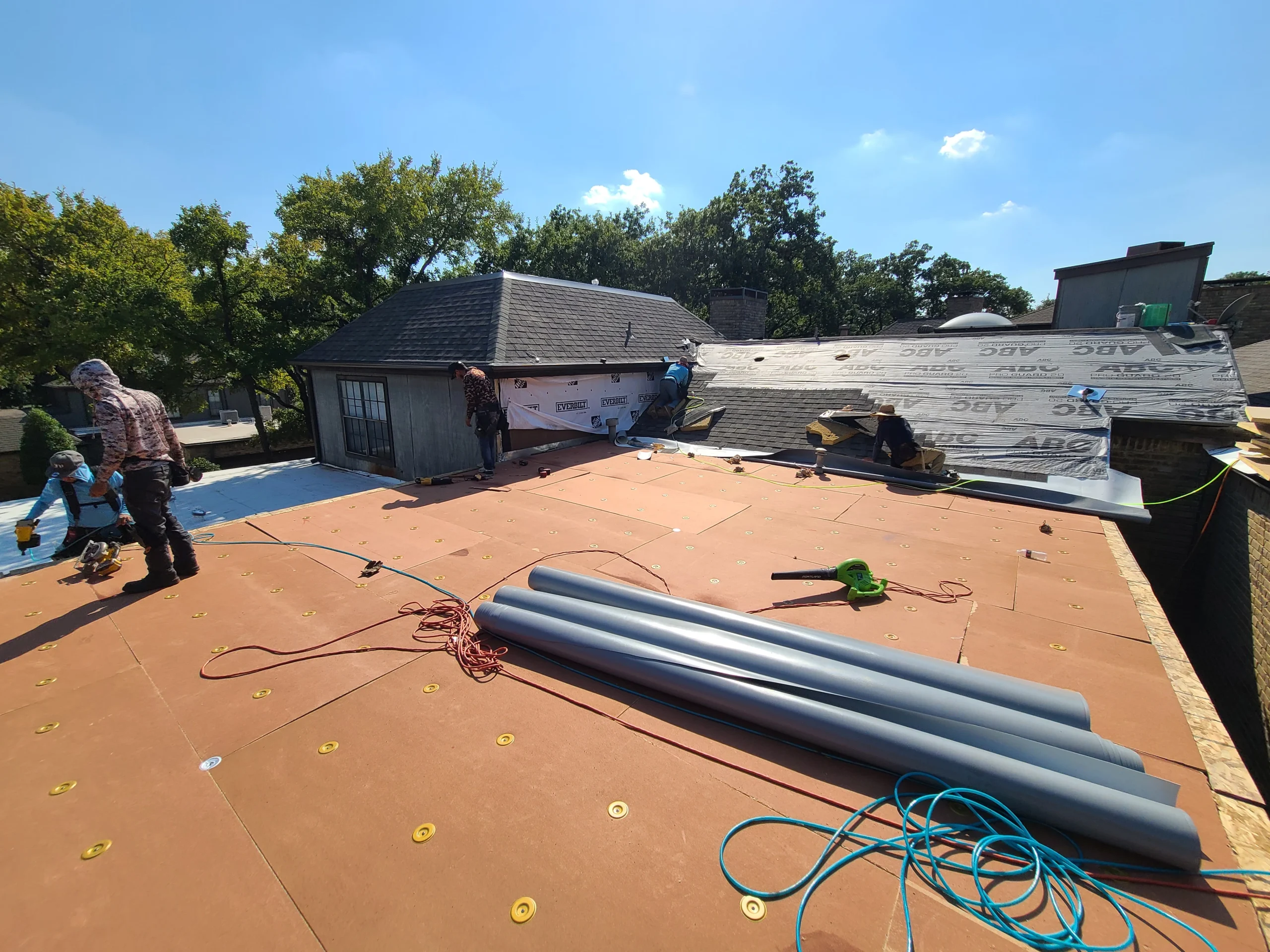 Crew installing flat roof base layer