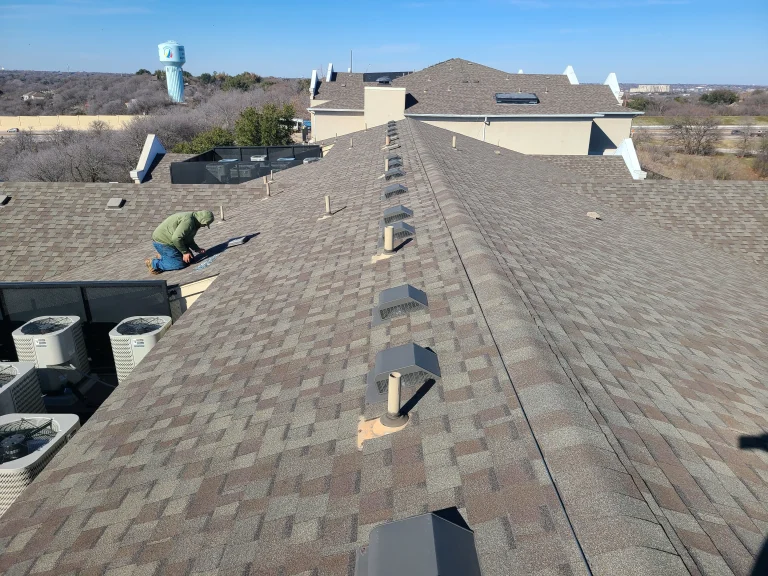 Crew replacing shingle roofing on a multifamily building