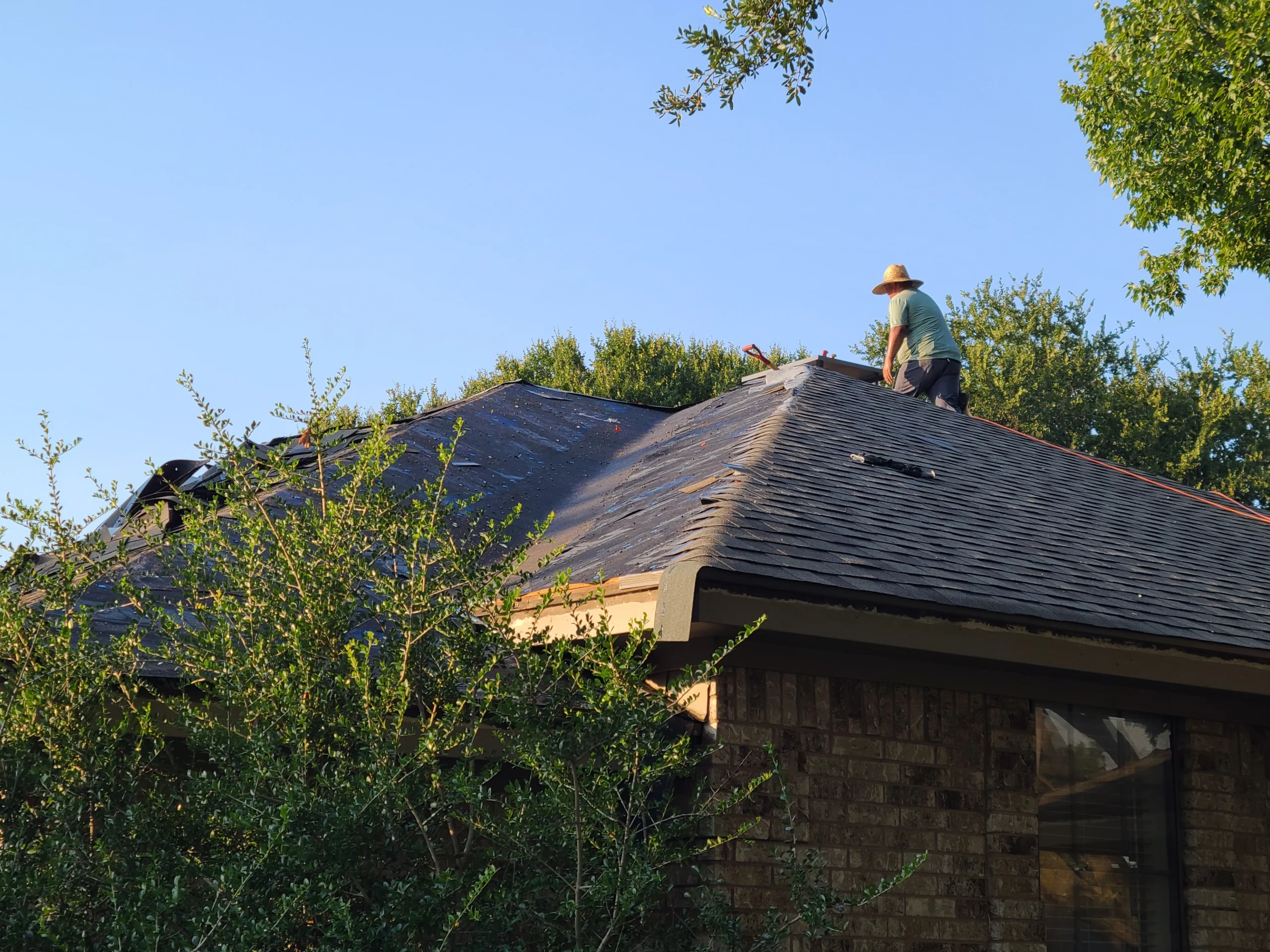Residential shingle roof installation at dusk