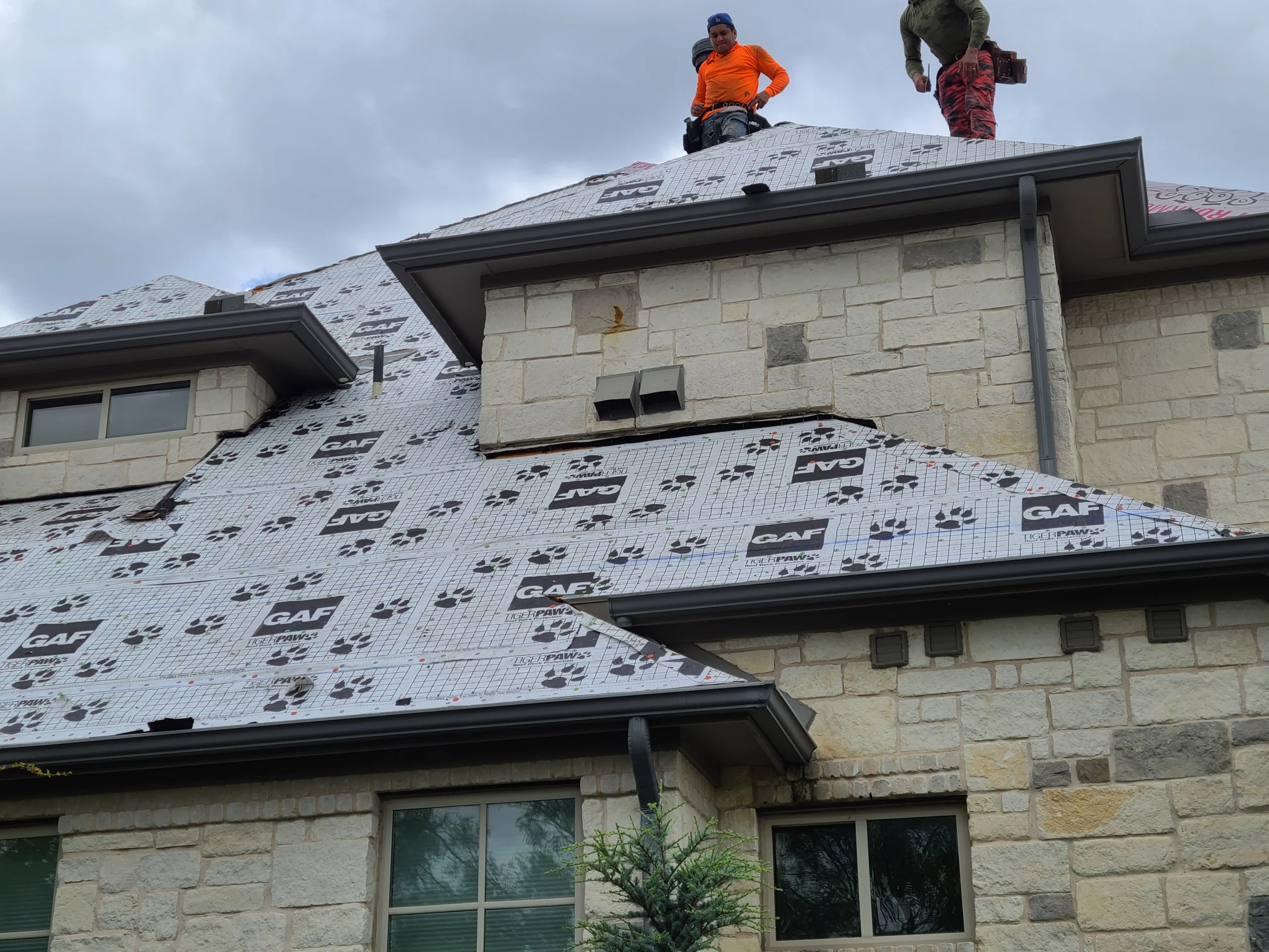 Roof underlayment installation on a stone-front home