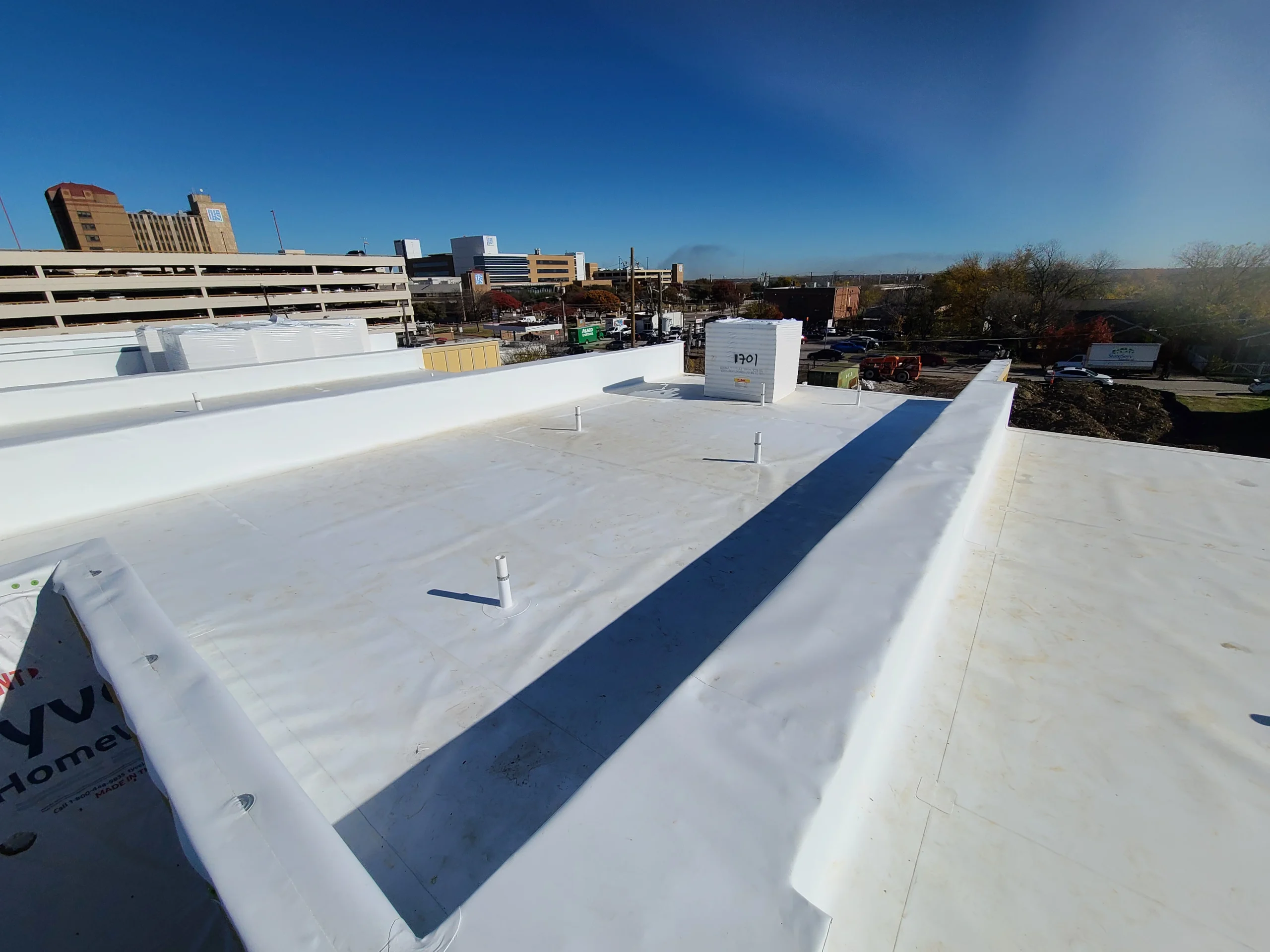 TPO membrane roof with walkway pads running along a parapet wall