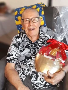 Leaving a Legacy: Hawaiʻi Foodbank supporter smiling with a gold gift basket